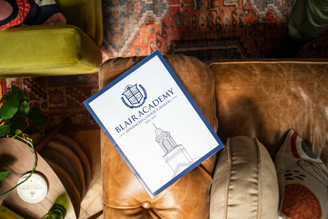 Blair Academy brochure rests on a leather couch near a plant.