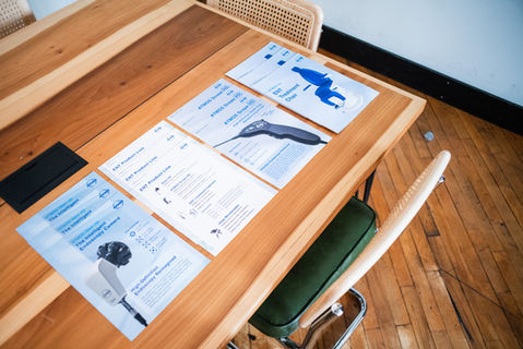 Documents with text on wooden table, with chair and bag.
