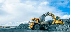 Work of trucks and the excavator in an open pit on gold mining, soft focus.jpg