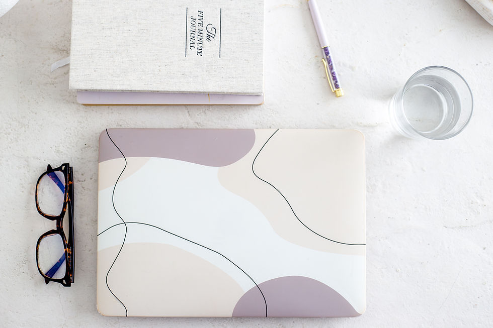 Laptop journal and glasses on a desk