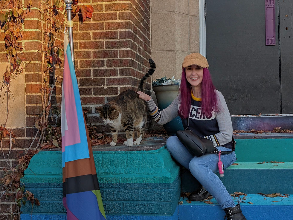 Nikol Allee with a cat she met on vacation sitting on steps