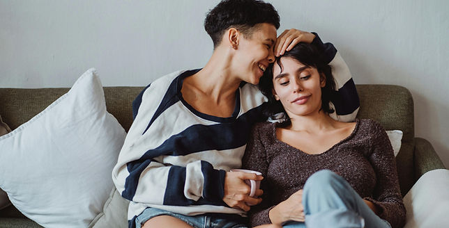 LGBTQ happy couple snuggled on a couch