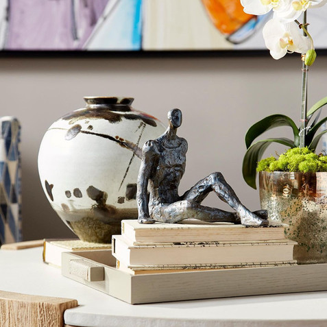 Small sculpture in front of vase.