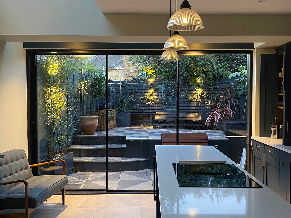 View of a Kitchen extension in London by Open Volume Studio for a luxury architectural project showing sliding doors and natural light at dusk