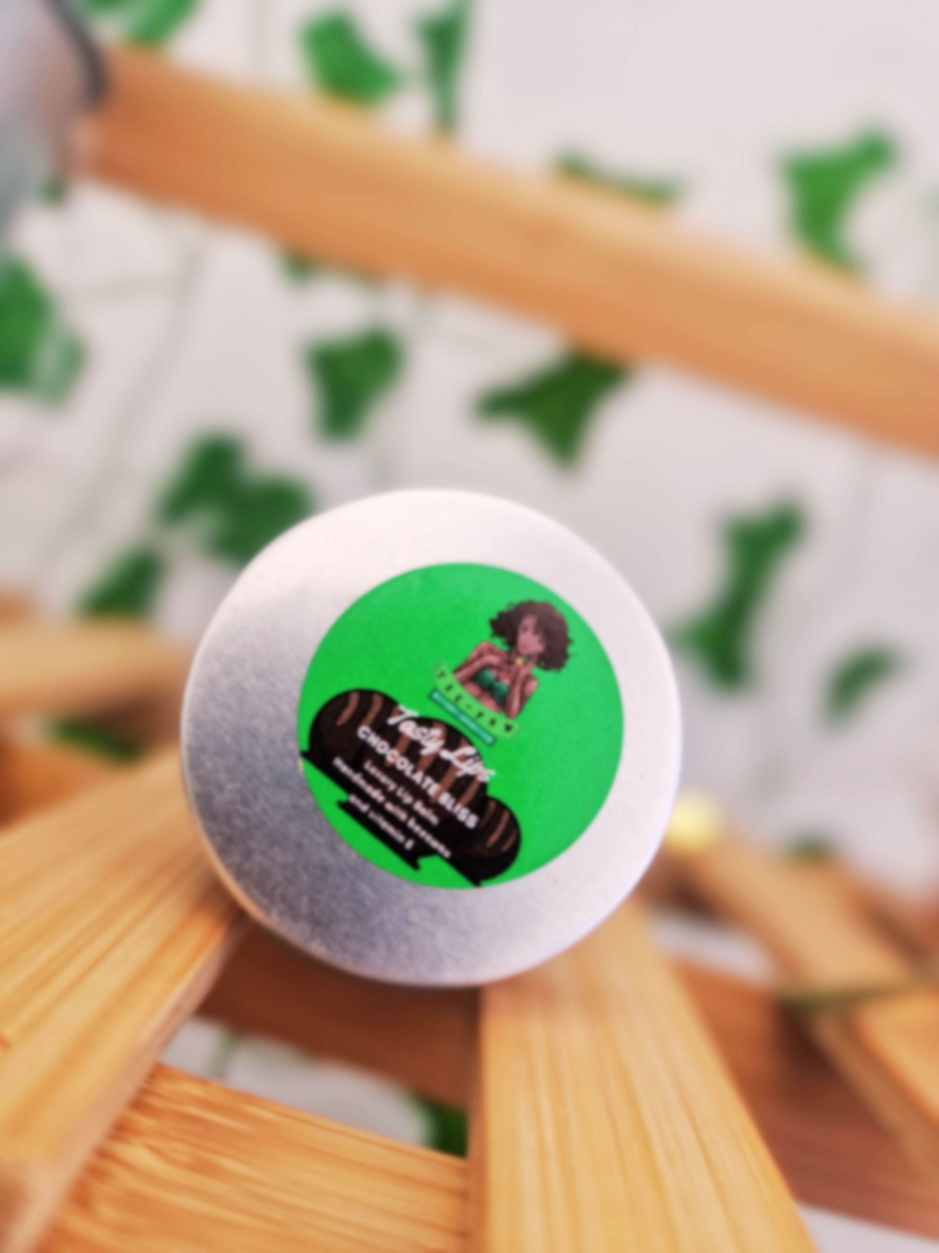 Chocolate Bliss Lip Balm by Tasty Lips from Tee Pow Cosmetics, displayed against a beautiful store backdrop