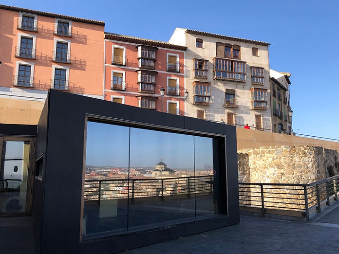 Mehrere Hausfassaden mit einer Spiegelung in einer grossen Scheibe mit einem Panoramablick.