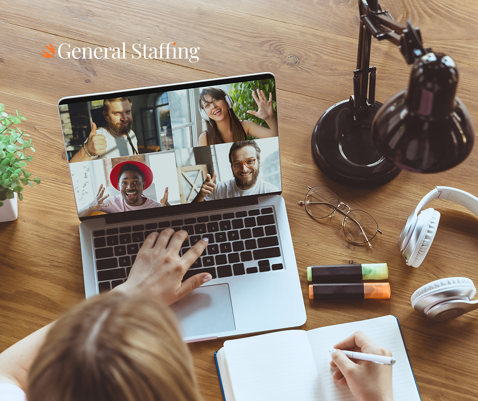 A person talking to their remote team through a videocall on a laptop. The laptop is placed on a brown table and there is a lamp, headphones, glasses and some highlighters