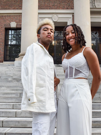 Two Harvard students stand on the steps of Widener Library dressed in all white for Black Convocation 2022