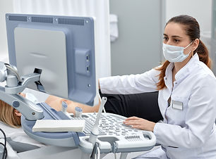 female-doctor-gives-the-patient-female-abdominal-ultrasound-ultrasound-scanner-in-the-hand