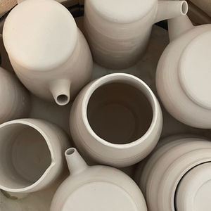 Unglazed ceramic jugs and vessels arranged inside the kiln at Studio Marvila, Lisbon.