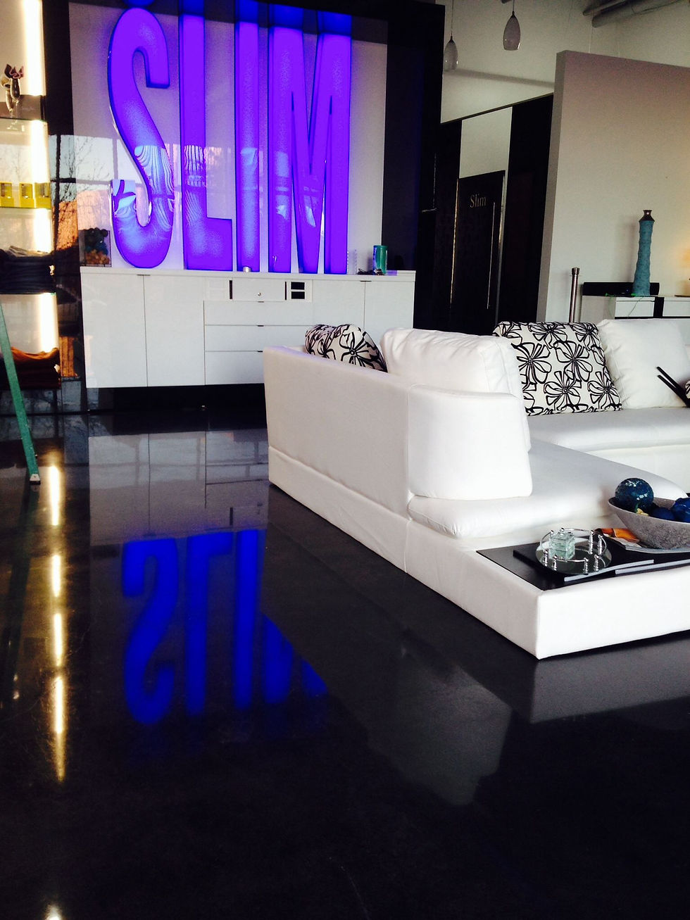 Black stained and polished concrete floor in a high-end clothing retail store, reflecting modern interior decor.