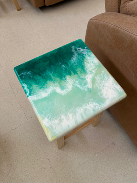 Vista cenital de un banco con diseño de "orilla de playa" en resina verde esmeralda y blanco, resaltando el brillo y la textura del acabado.