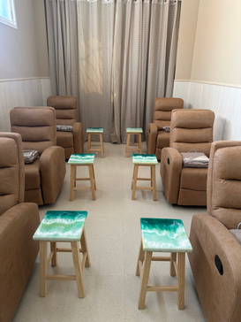 Conjunto de cuatro taburetes dispuestos en una sala de estar, mostrando la variedad de diseños botánicos y costeros en sus superficies.