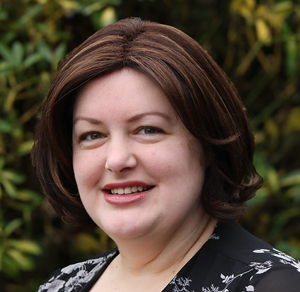 Samantha, Trustee and facilities manager; Smiling brown shoulder-length hair, floral top