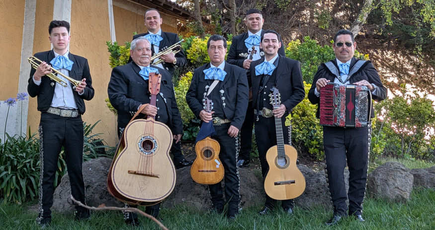 Mariachi México Lindo ensemble portrait featuring trumpet, violin, guitar, guitarrón, and accordion musicians in traditional charro attire.