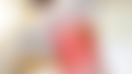 Man holding his back with both hands, showing pain. Red highlight with a spine graphic. Bedroom setting, neutral colors.