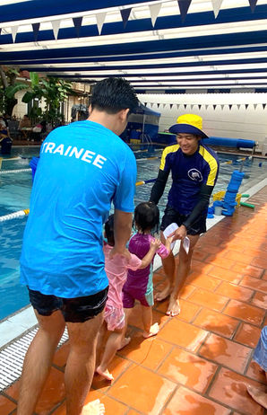 Swim teacher guiding children at the poolside during lessons at Australia Swim School Thao Dien, focusing on safety and technique. Next stop, confidence.