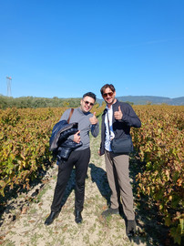 two people standing in a vineyard
