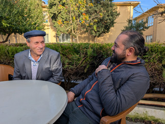 two men sitting and talking