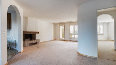 Blick auf den unmöblierten Wohnzimmer-Bereich mit Cheminée/Kamin