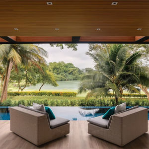 Covered outdoor terrace at Singapore Sentosa Cove  with timber ceiling and lounge chairs overlooking an infinity pool, lush tropical garden, and tranquil lake view, creating a seamless indoor-outdoor living experience