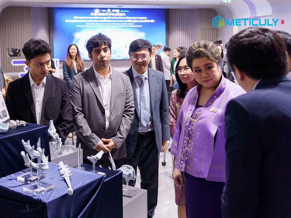 Ms Supamas Isarabhakdi holds a 3D-printed medical implant. Medical models are displayed on a blue surface to the left.