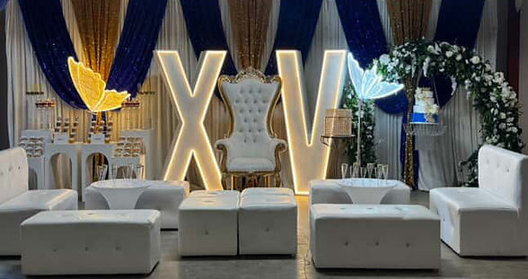 throne chair flanked by large lighted marquee letters with loung seating in the foreground and decorative drapes in the background