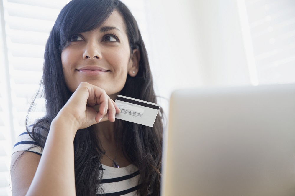 Mujer joven contemplando compras por internet