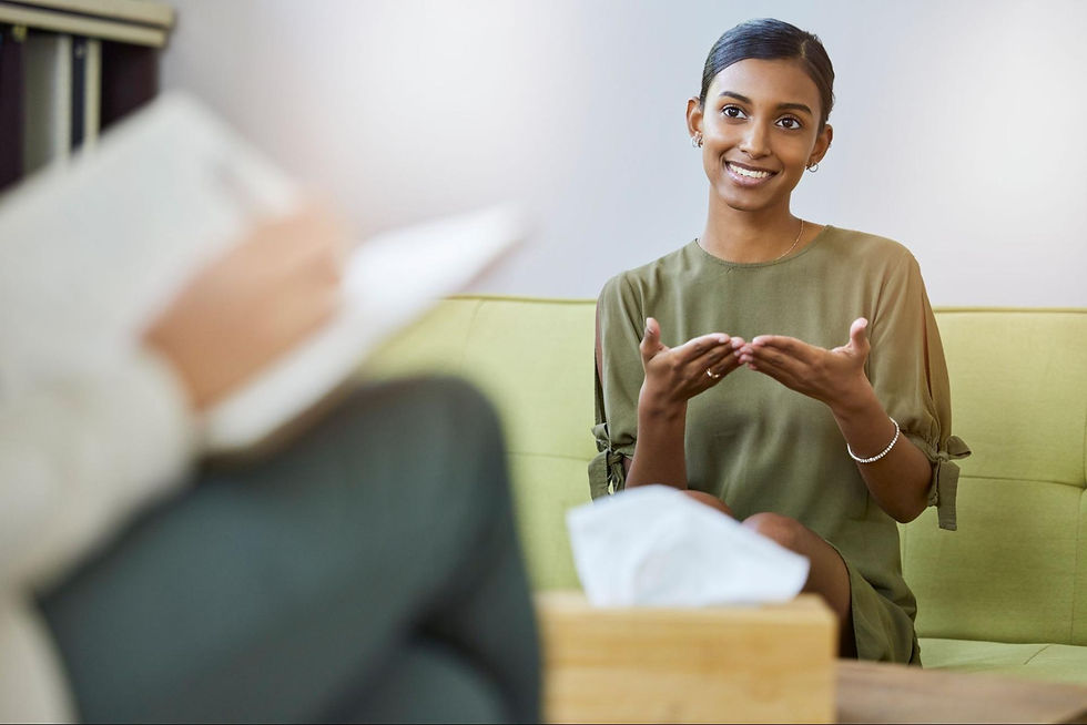 Woman sitting on a couch across from a therapist.