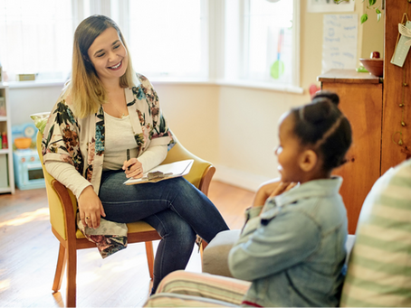 A therapist talking to a child.