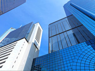 Upward view of skyscrapers against a clear, blue sky.