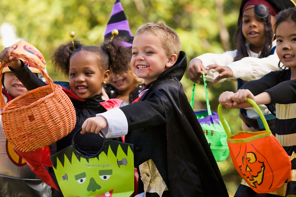 Costumed kids holding trick-or-treat bags at a kid friendly haunted house event in Los Angeles