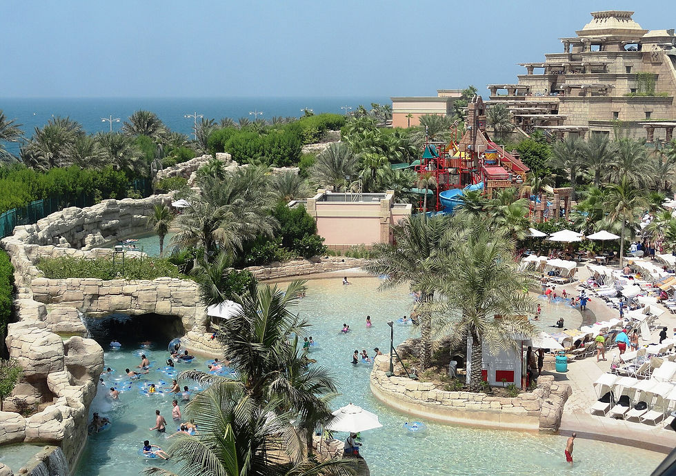 Rocky lagoon, palm trees and slide towers at Aquaventure water park at Atlantis The Palm in Dubai