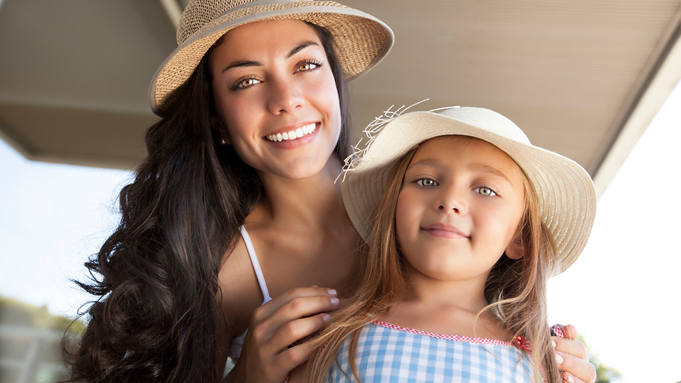 Mother and young daughter wearing sun hats and smiling, perfect for a family-friendly mother-daughter date ideas.