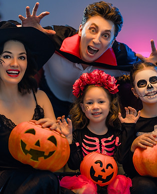 Mother, father and their kids having fun at home. Happy family celebrating Halloween. Peop