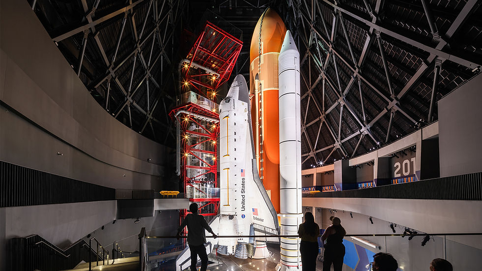 Space Shuttle Endeavour displayed upright with its orange external tank and rocket boosters inside the Samuel Oschin Air and Space Center in Los Angeles
