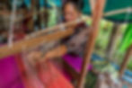 Local woman weaving silk by hand on a traditional loom in a Mekong village, showcasing the timeless craft and cultural heritage of Southeast Asia