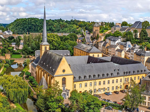 Luxembourg City with historic buildings, a stone bridge, and the Alzette River flowing through the valley