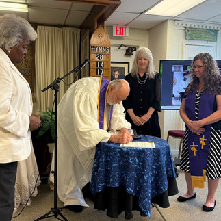 Rev. Bill Whitley touches Rev. Trish’s hand, which is placed on her heart, as he ordains her a minis