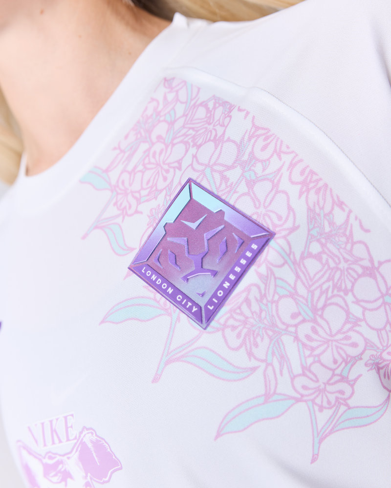 The crest in lilac and mint, framed by the shirt's floral print