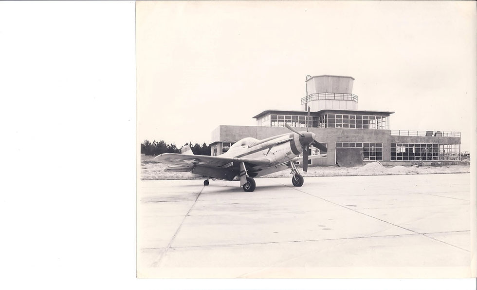 Vintage propeller plane parked near airport control tower