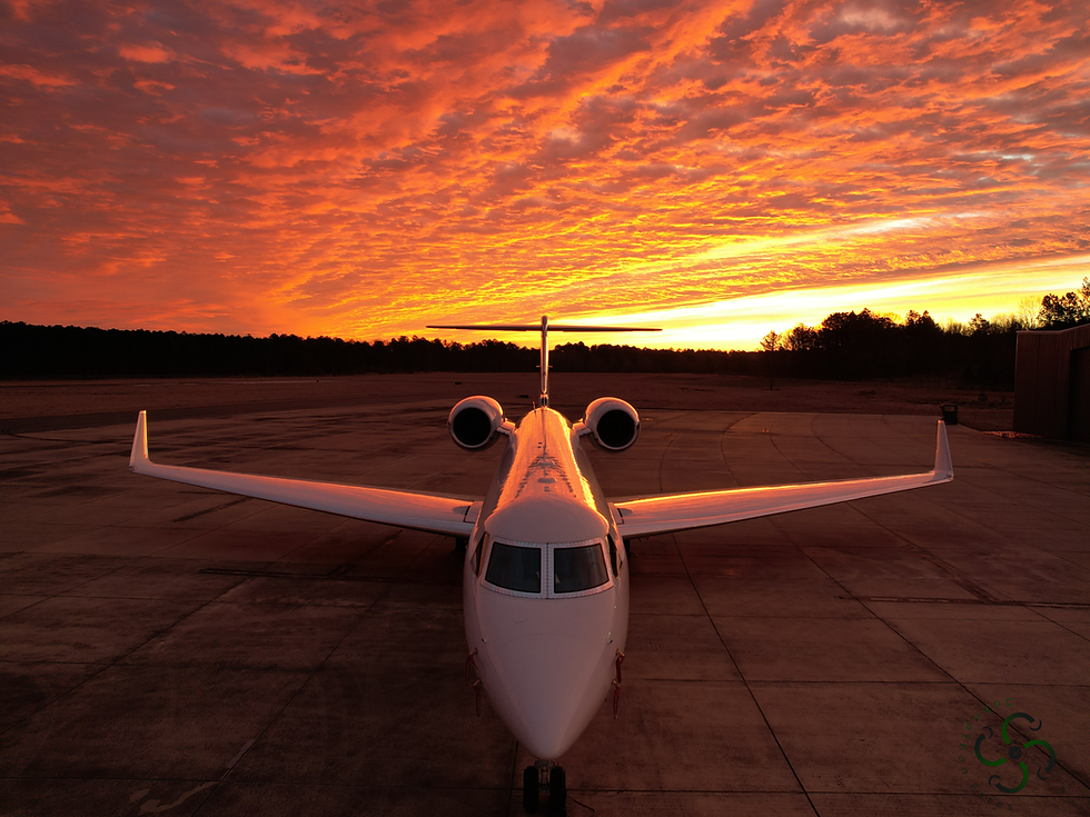 Private jet on runway during vibrant orange sunset
