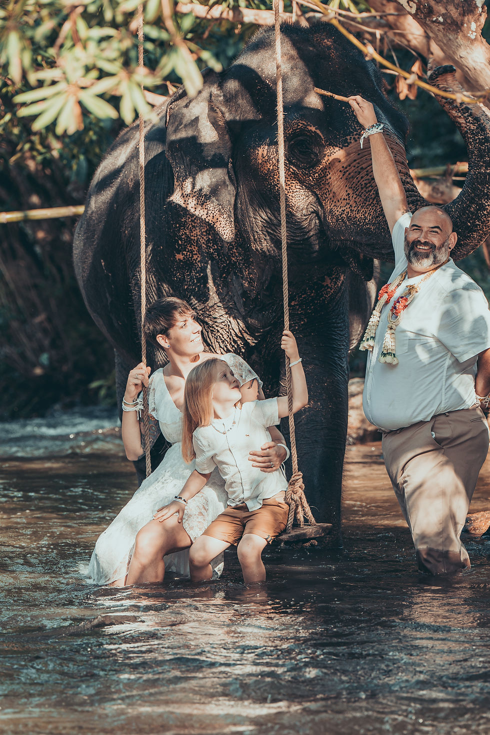 Mum, Dad and son on wedding day with elephant in the river