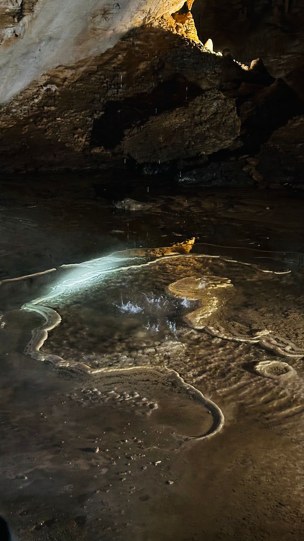 a natural pool forming from the water ouside of the cave