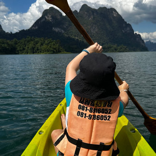 Jax Kayaking on Cheow Lan Lake with limestone cliffs in the background