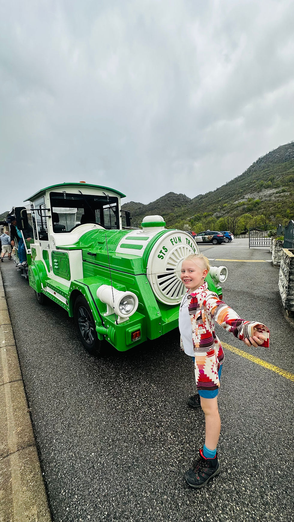 Boy standing in front of a small train