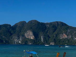 Long Tail Boat in the ocean with limestone cliffs