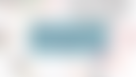 A desk space with snacks, flowers, a laptop, planner, and notebook