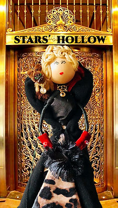 blonde movie star doll with cat in black cape and red gloves 