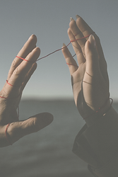 Mains reliées par un fil symbolisant le lien invisible entre les générations